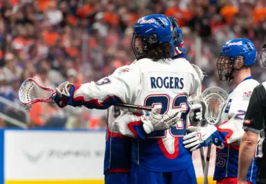 Lacrosse player receiving celebratory hug from teammate