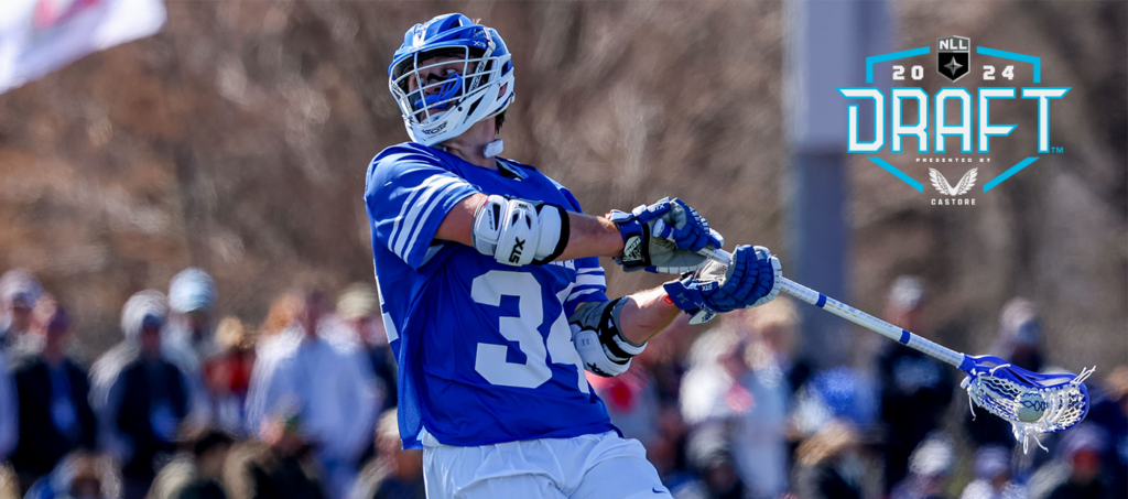 Lacrosse player wearing a blue jersey shoots the ball while a crowd watches, with the 2024 NLL Draft logo prominently displayed.