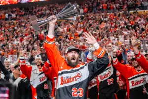 Buffalo Bandits player number 23 celebrates victory holding a trophy, crowd cheering
