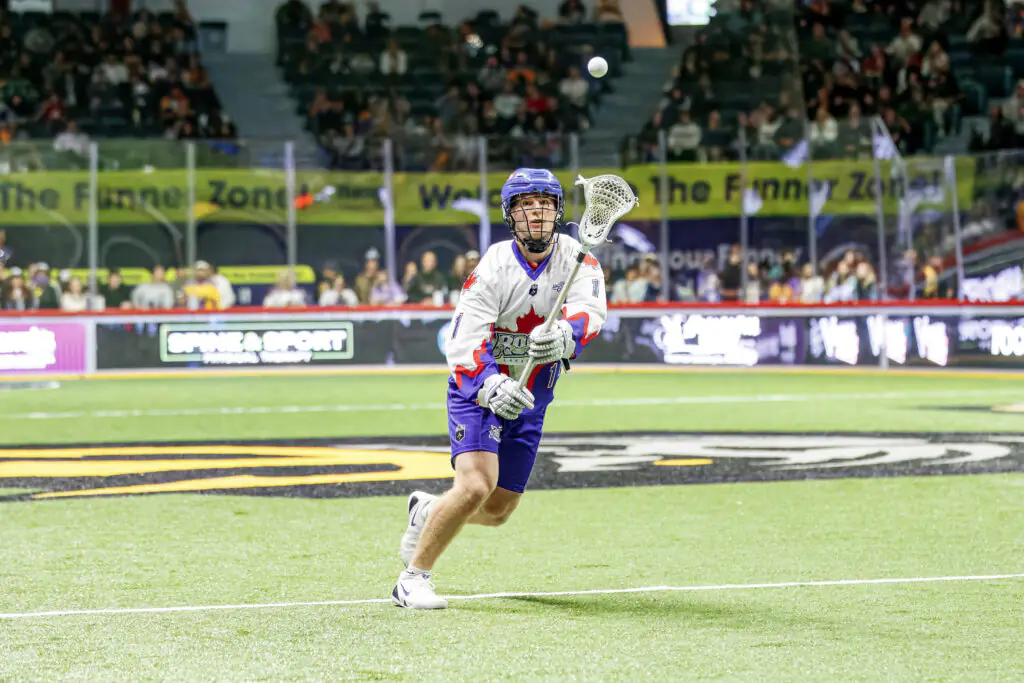 Lacrosse player in action during a match, catching a ball