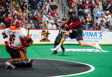 Buffalo Bandits player attempts to score against Colorado Mammoth during a lacrosse game