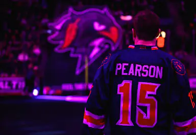 Back view of a player named Pearson wearing a number 15 jersey, facing a large illuminated logo