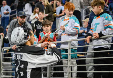 Blake signing autographs for excited young fans in sports jerseys