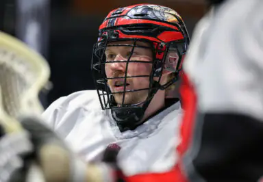 Lacrosse player with helmet and face mask in action